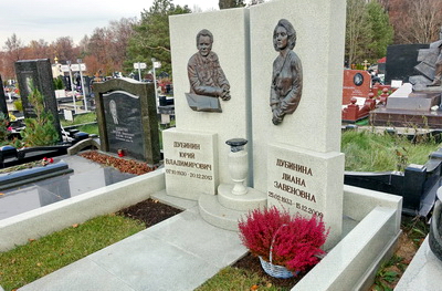 Два симметричных памятника с барельефами покойных